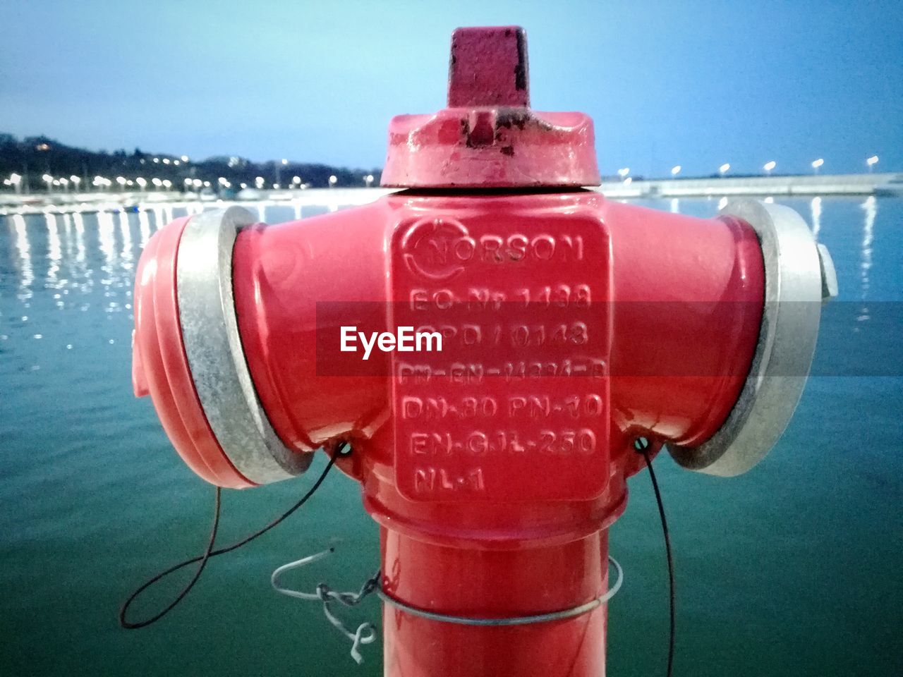 CLOSE-UP OF FIRE HYDRANT AGAINST RED WATER