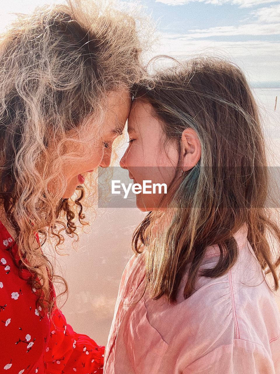 Side view of young woman and her daughter looking to each other