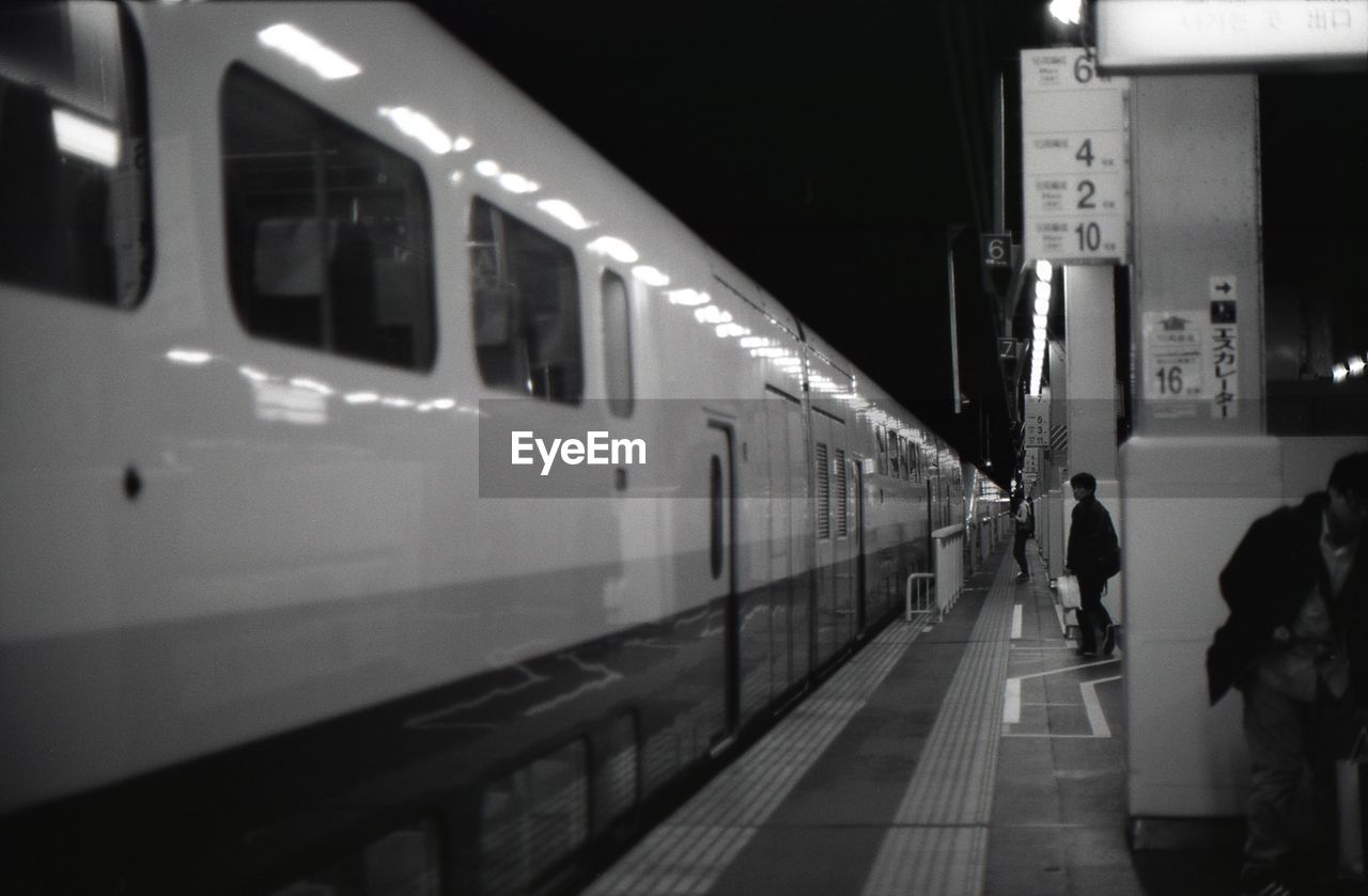 TRAIN ON RAILROAD STATION PLATFORM AT NIGHT