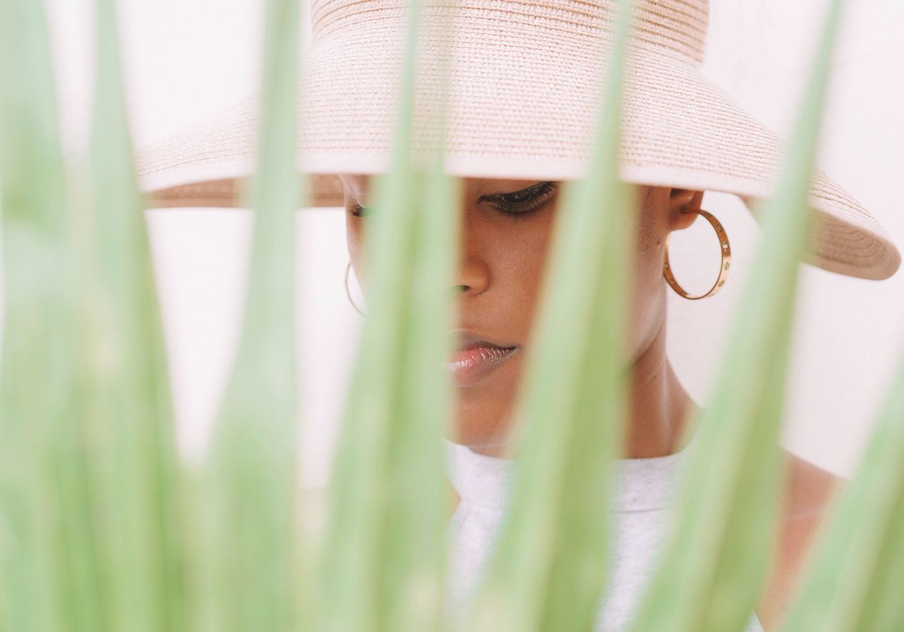 Close-up of woman looking down seen through plant