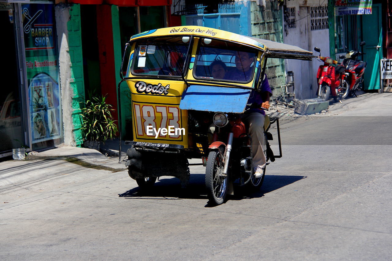 Man driving jinrikisha on city street