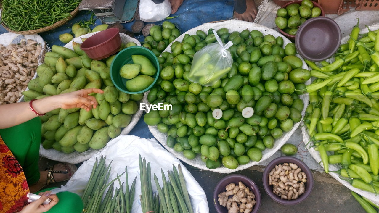 Low section of woman shopping fresh vegetables in market