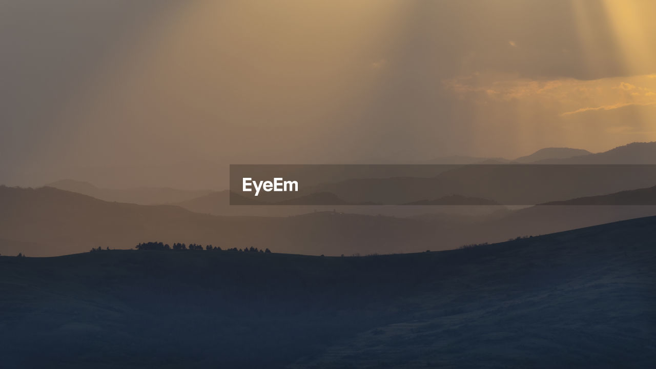 SILHOUETTE MOUNTAINS AGAINST SKY DURING SUNSET