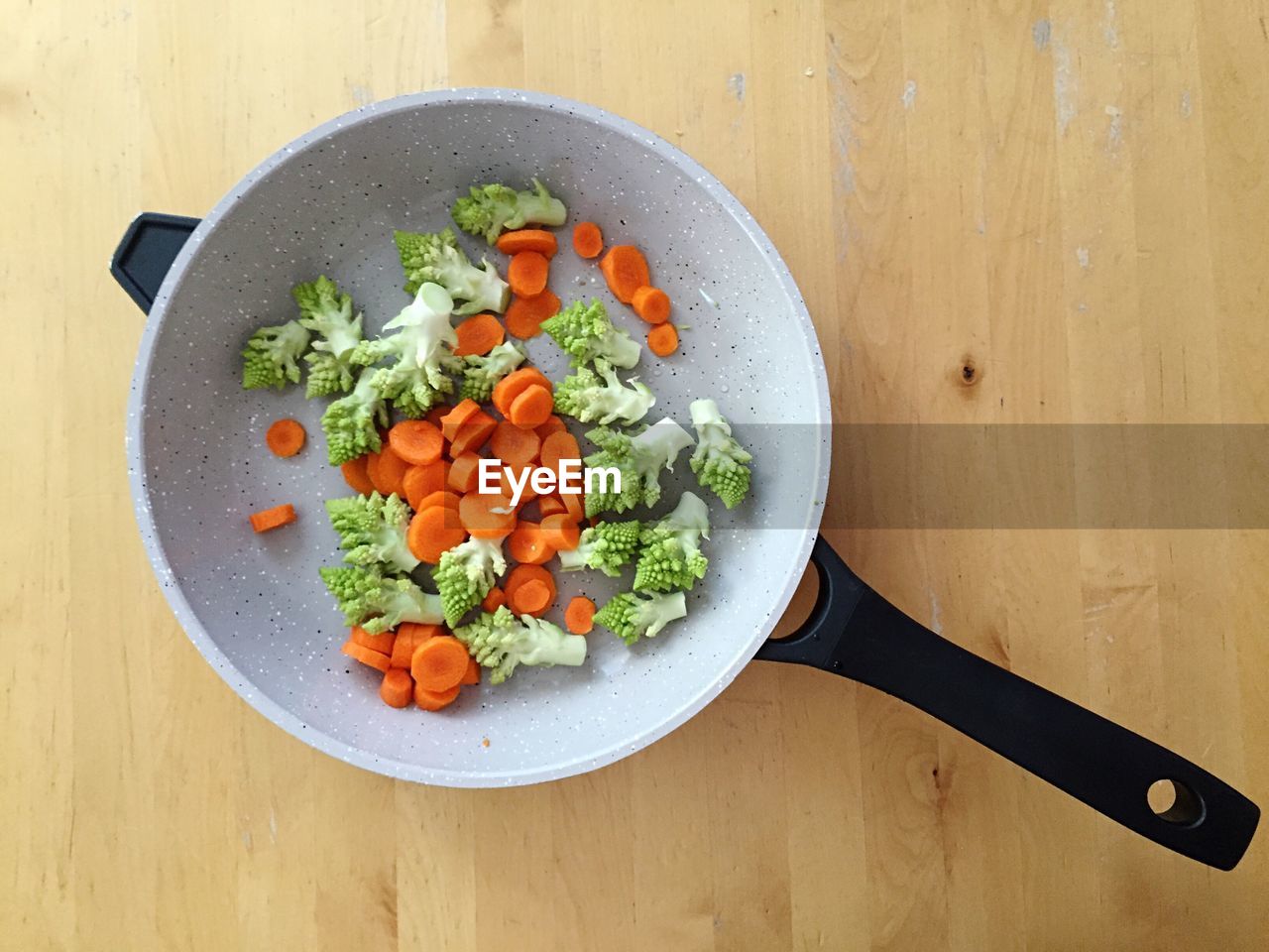 High angle view of salad in cooking pan on wooden table