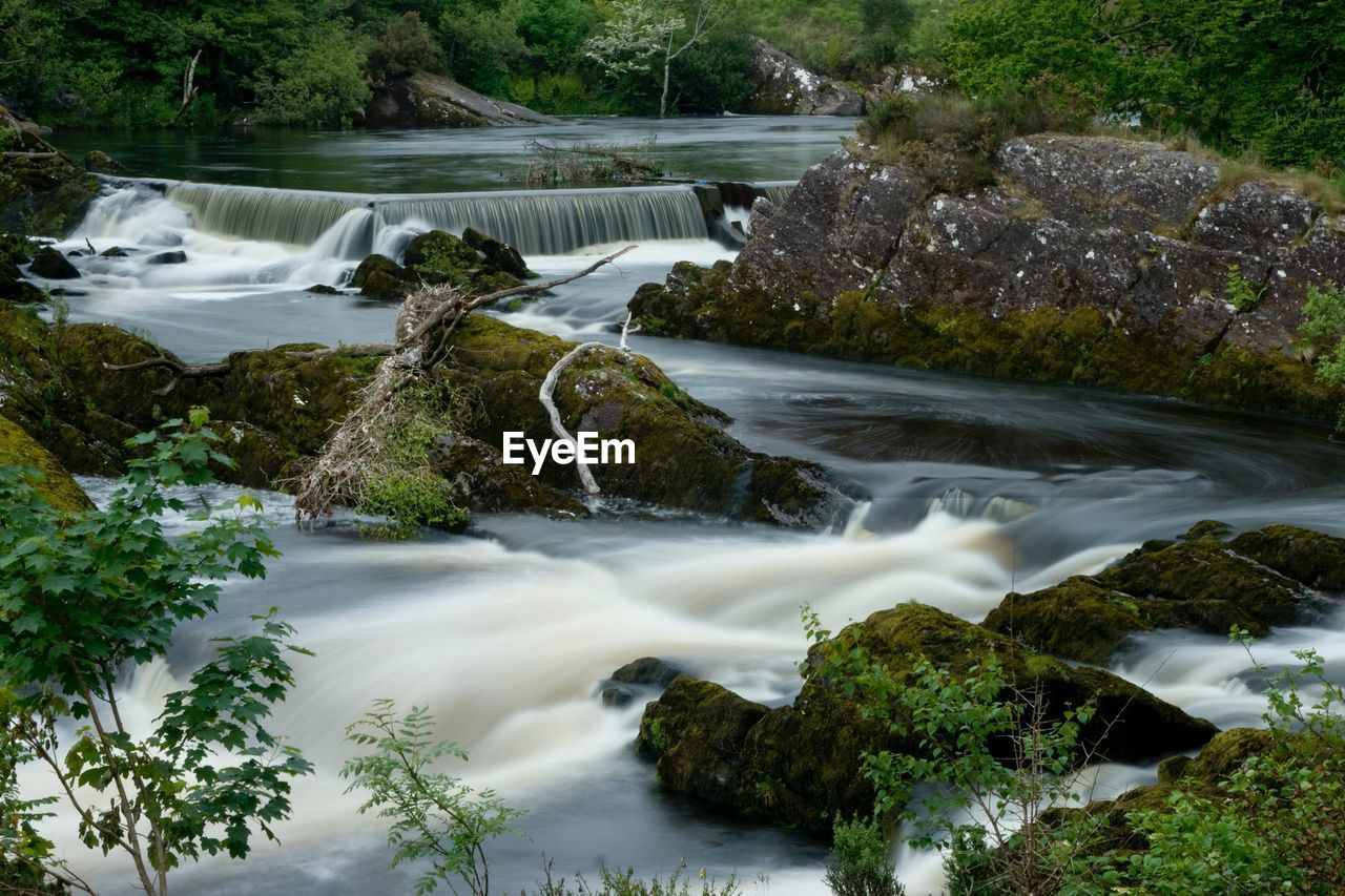 Scenic view of waterfall with stream in foreground