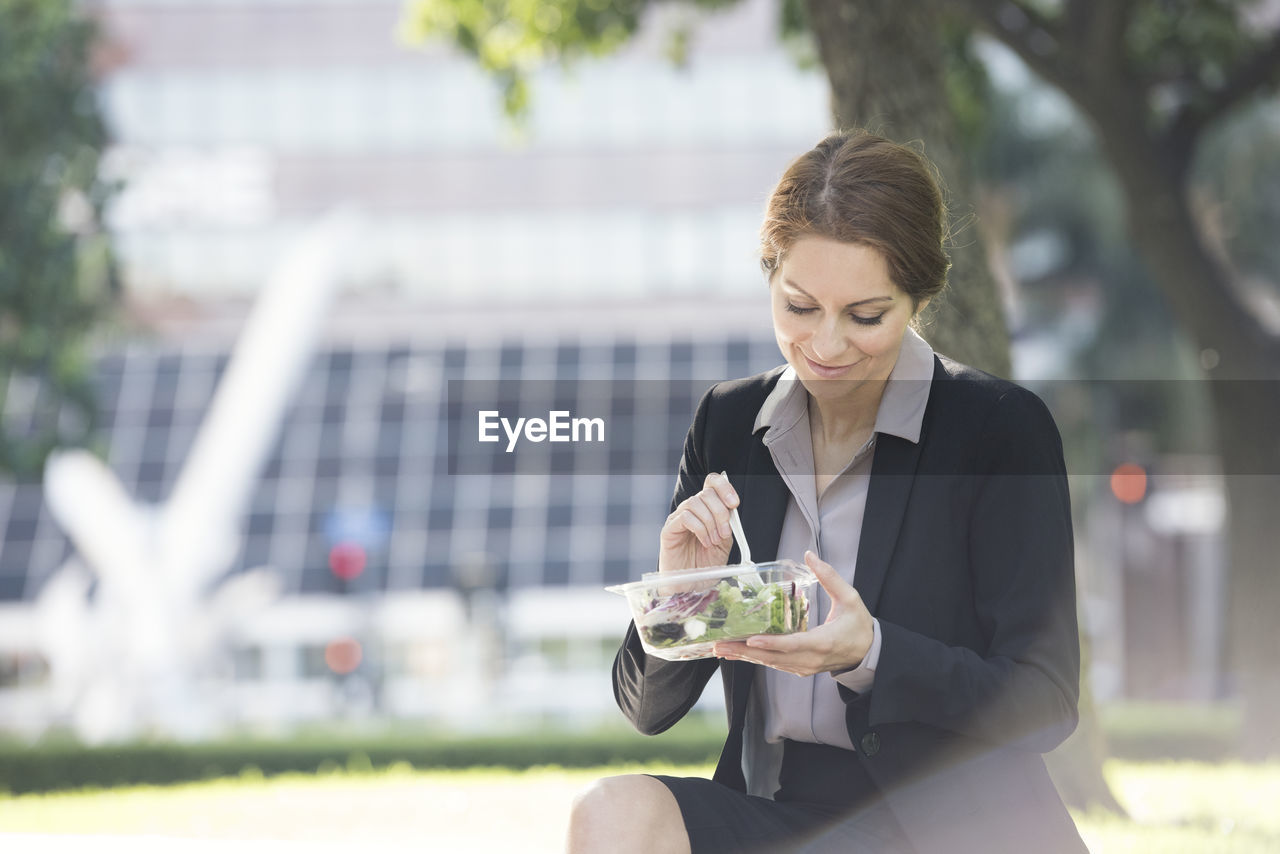 Businesswoman having lunch outdoors