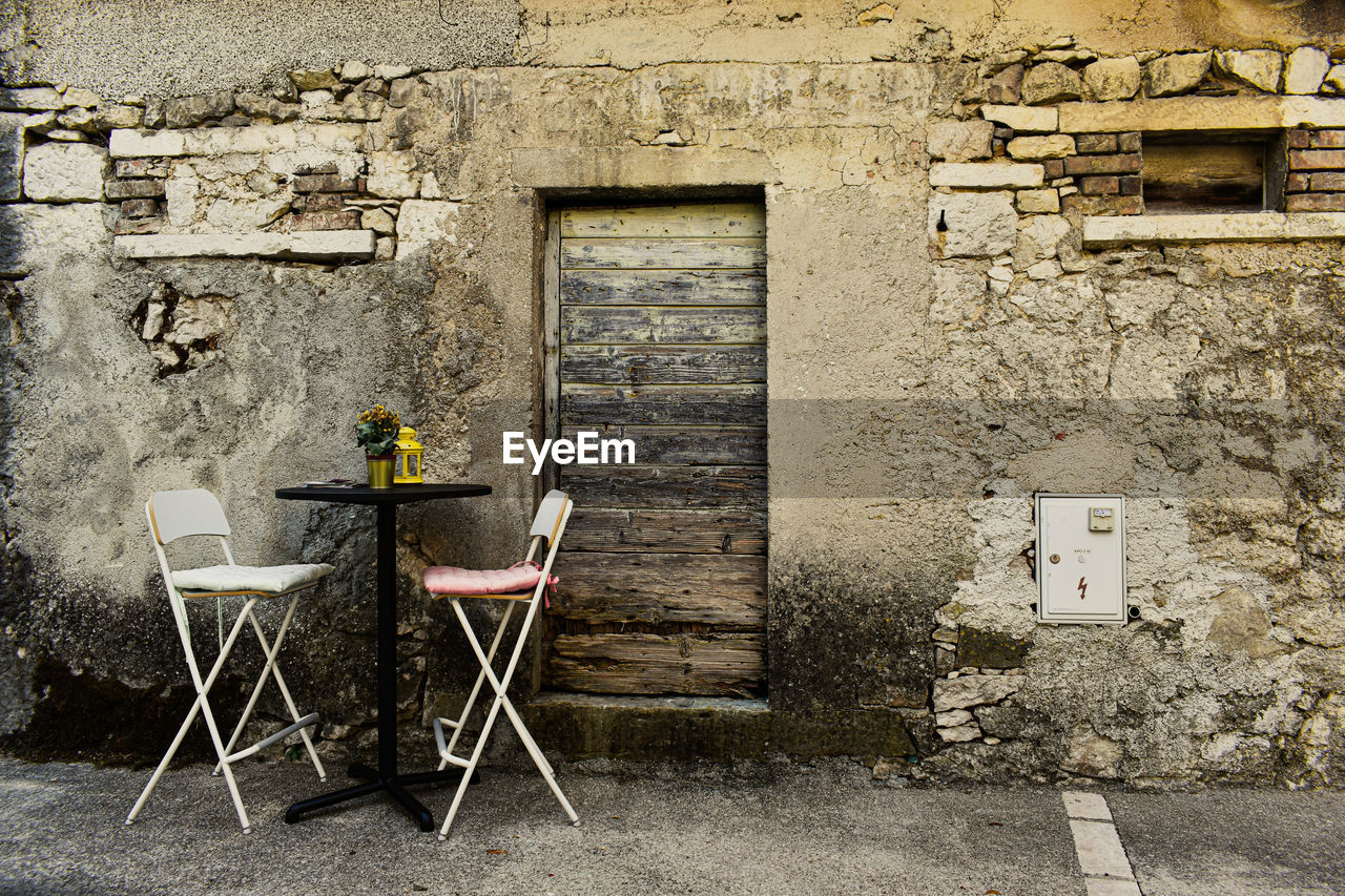Chairs and table against window of old building