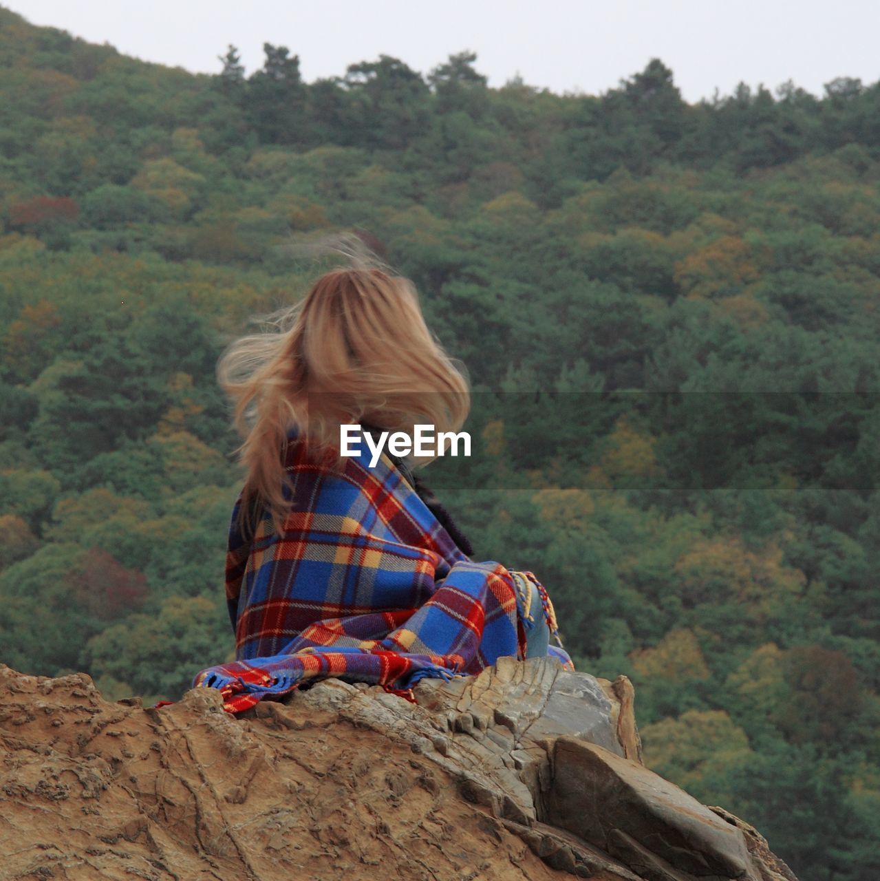 Rear view of woman sitting on mountain