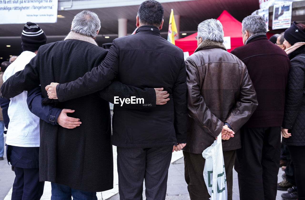 REAR VIEW OF PEOPLE STANDING ON THE FLOOR