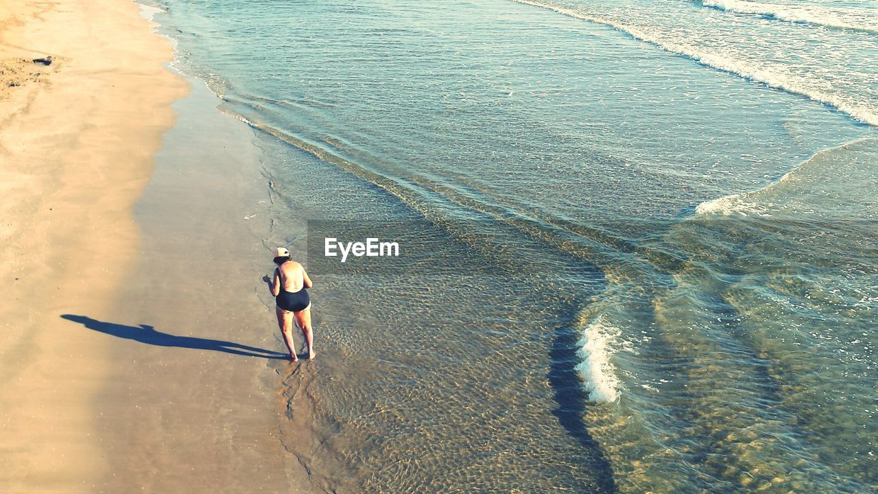 High angle view of woman standing at beach