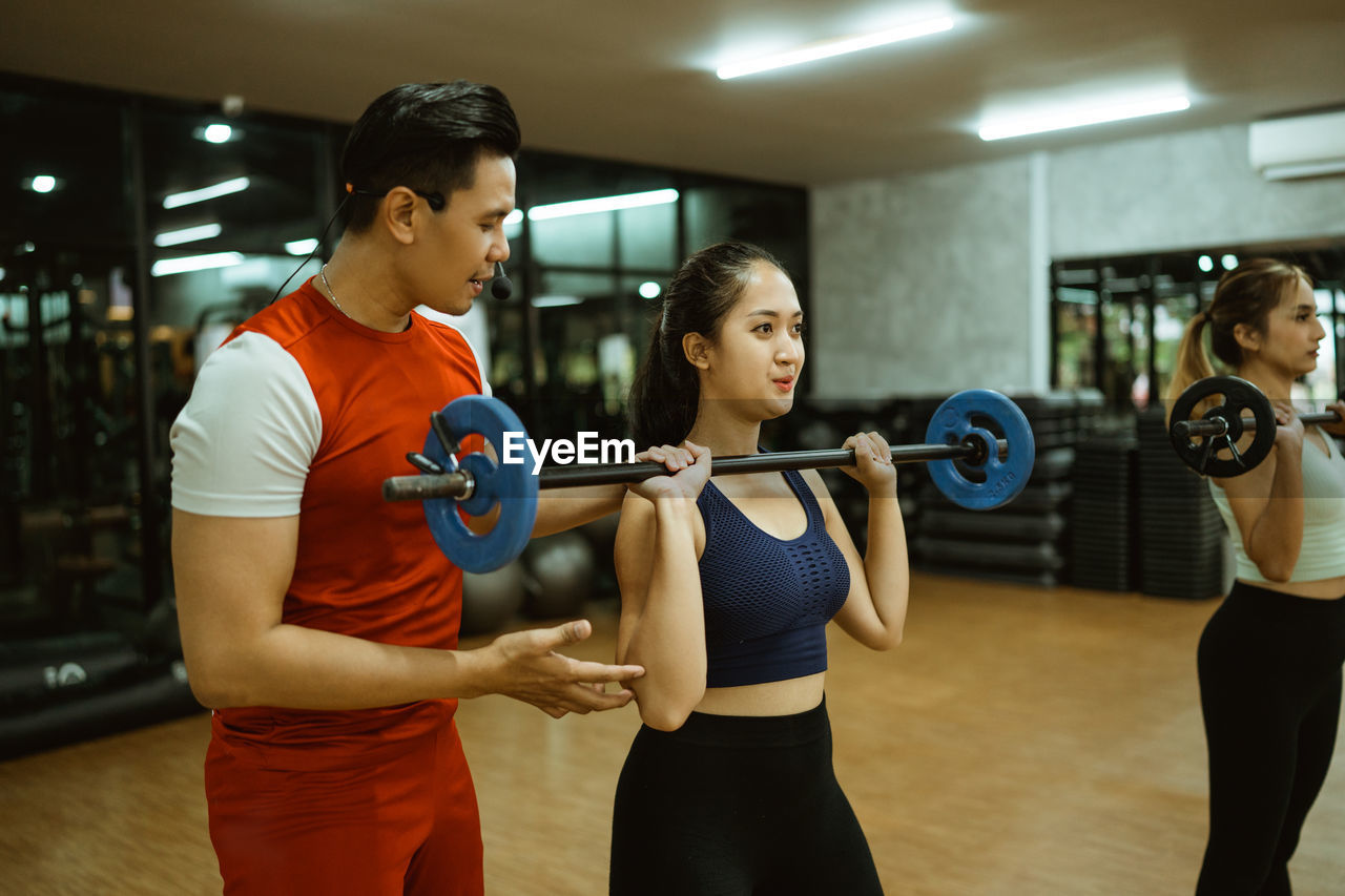 portrait of young woman exercising in gym
