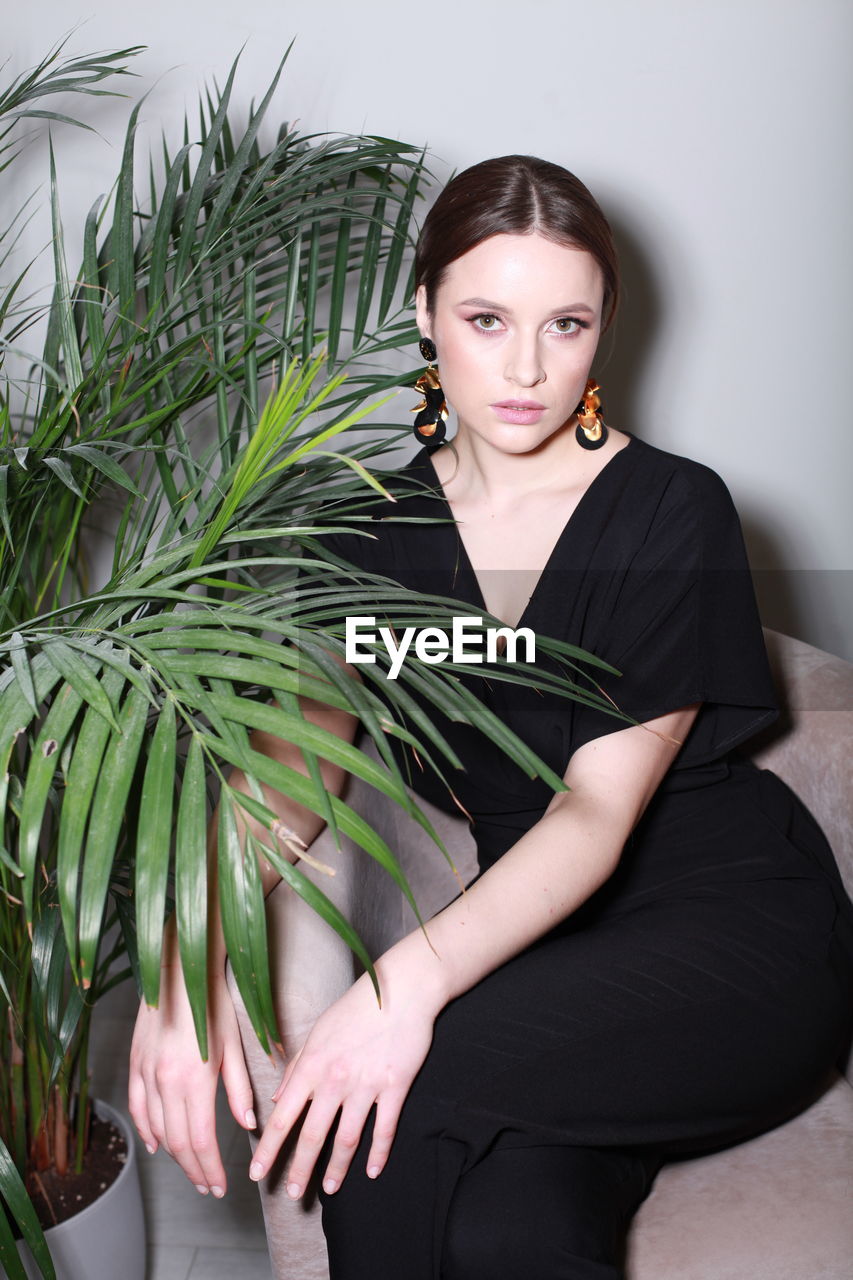 low angle view of young woman holding plant