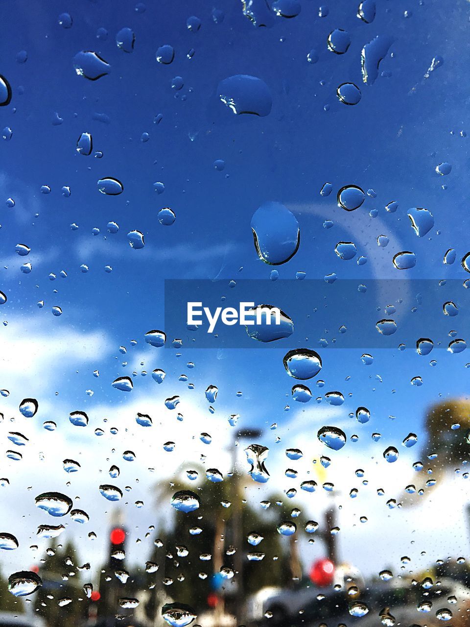CLOSE-UP OF CARS AGAINST SKY SEEN THROUGH CAR WINDSHIELD