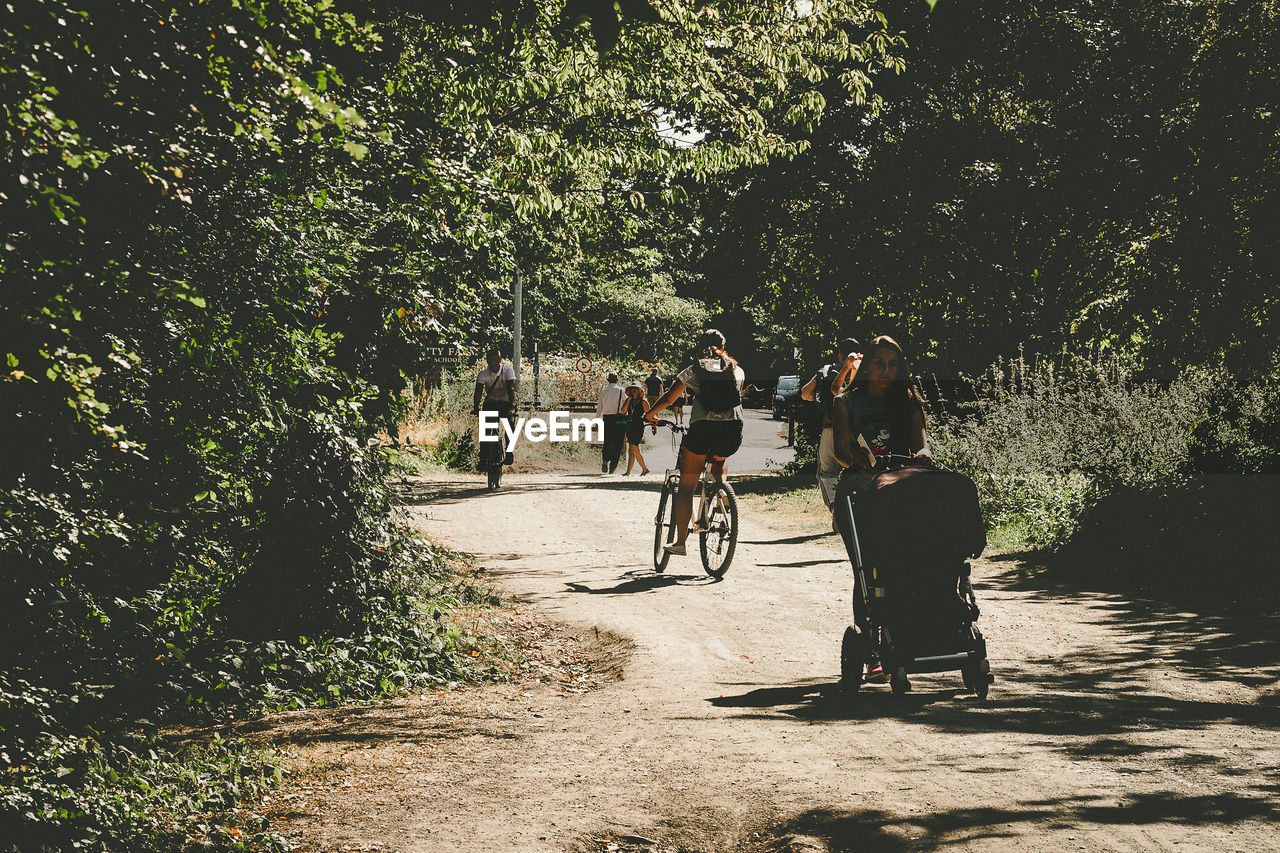 Rear view of people riding bicycle