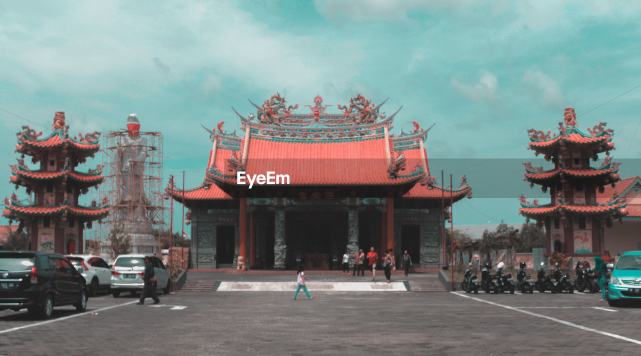 GROUP OF PEOPLE IN TEMPLE AGAINST BUILDINGS