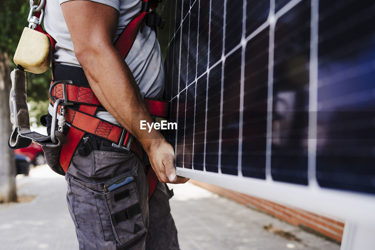 Technician carrying heavy solar panel