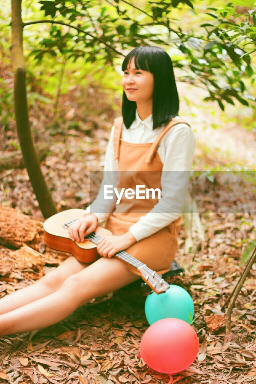 YOUNG WOMAN STANDING IN PARK