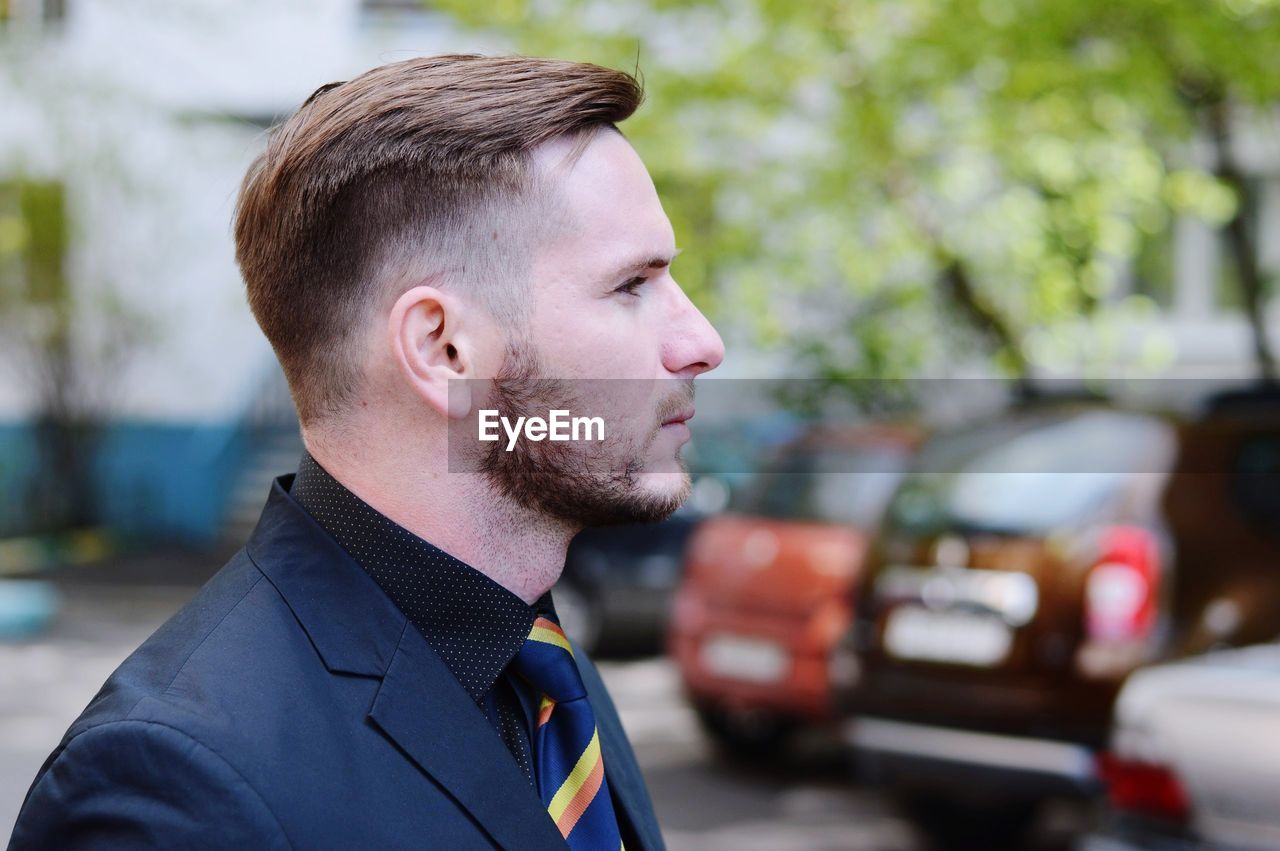 Side view of confident businessman in parking lot