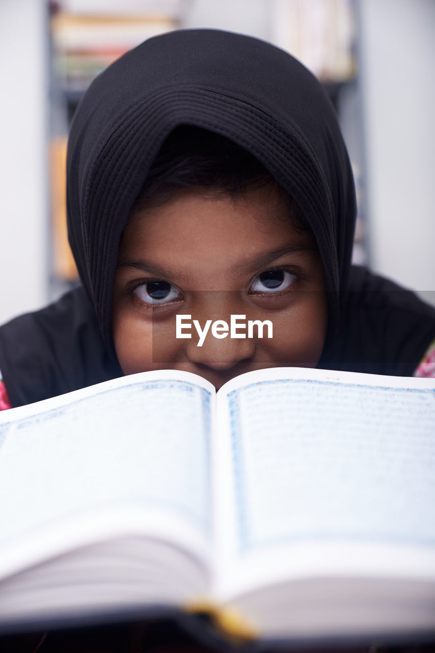 Cute muslim little girl reading koran