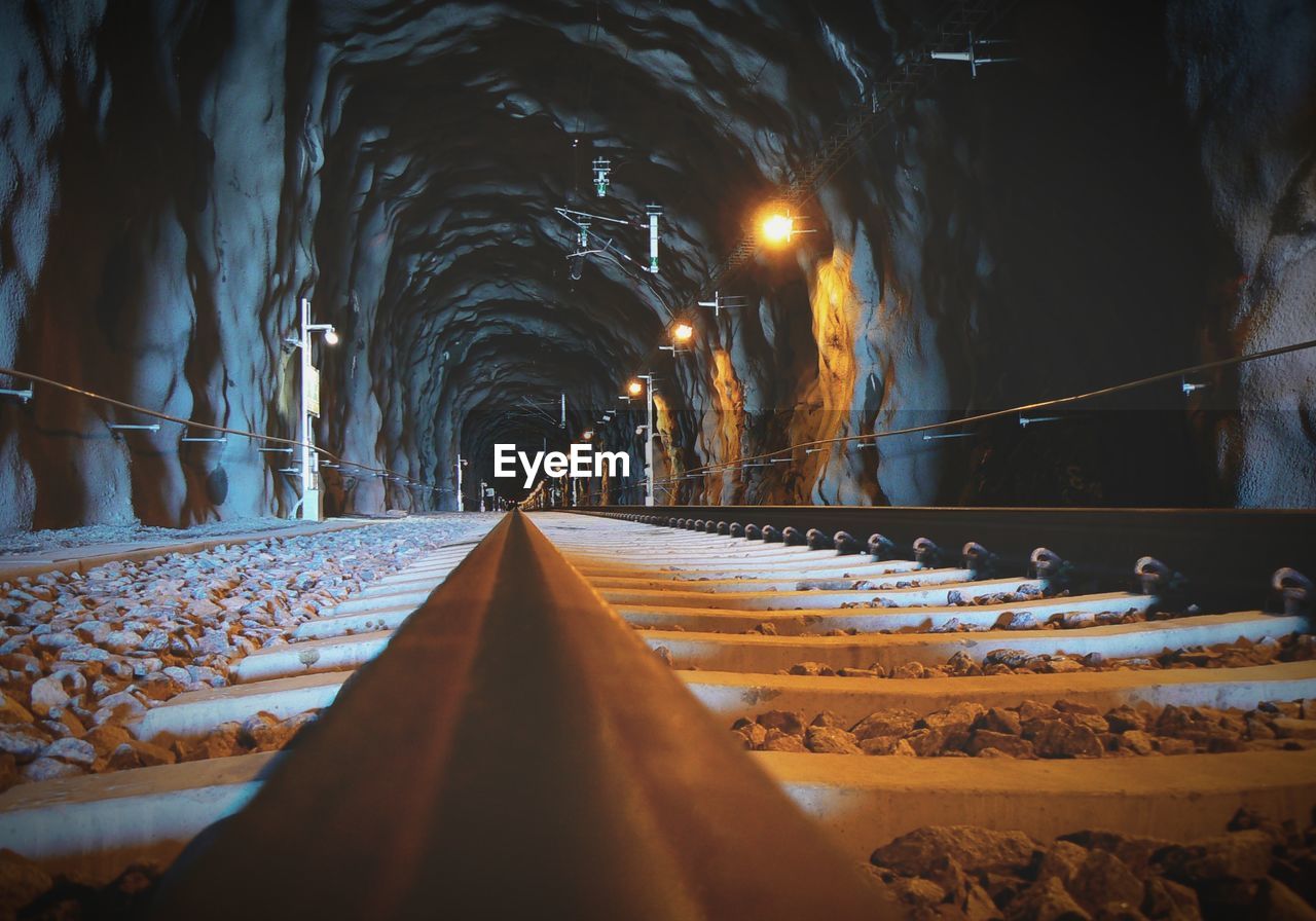 Surface level of railroad tracks in illuminated tunnel