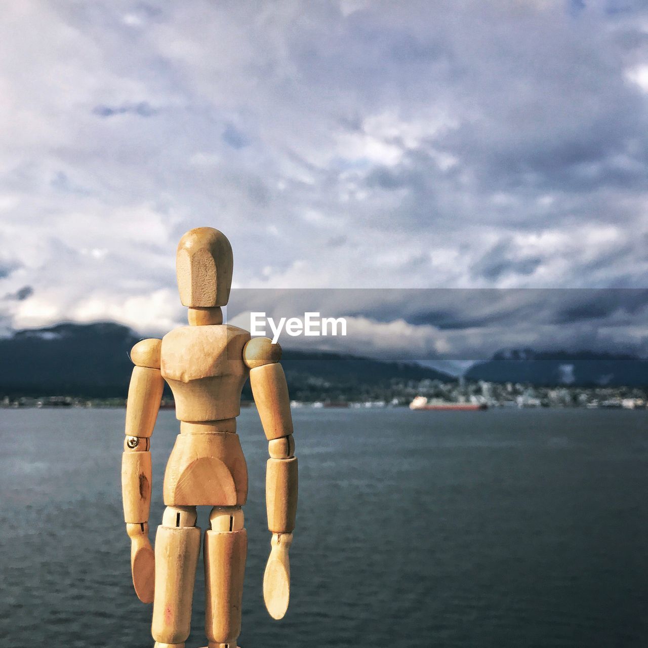 REAR VIEW OF STATUE AGAINST CALM SEA
