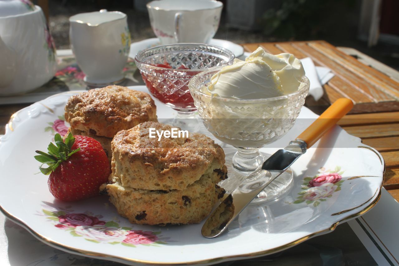 Close-up of scones by ice cream in plate on table