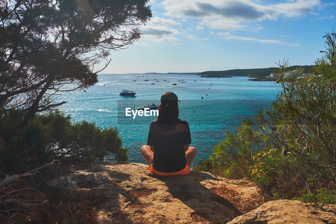 Rear view of woman looking at sea against sky