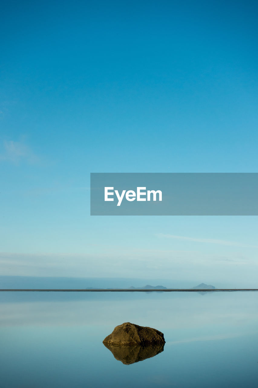 Scenic view of lake against clear blue sky