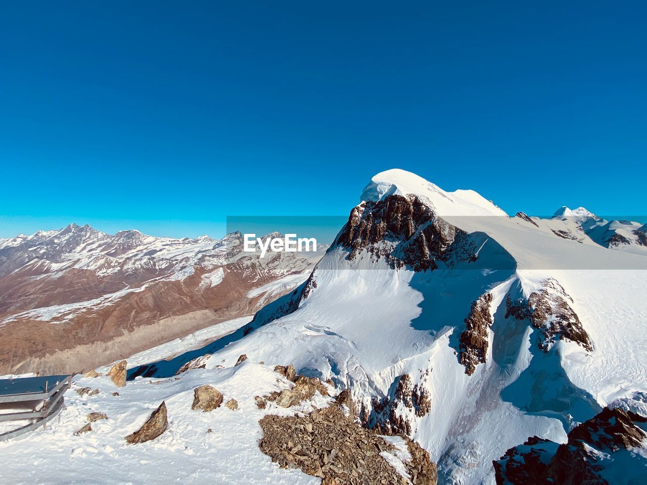 Scenic view of snowcapped mountains against clear blue sky