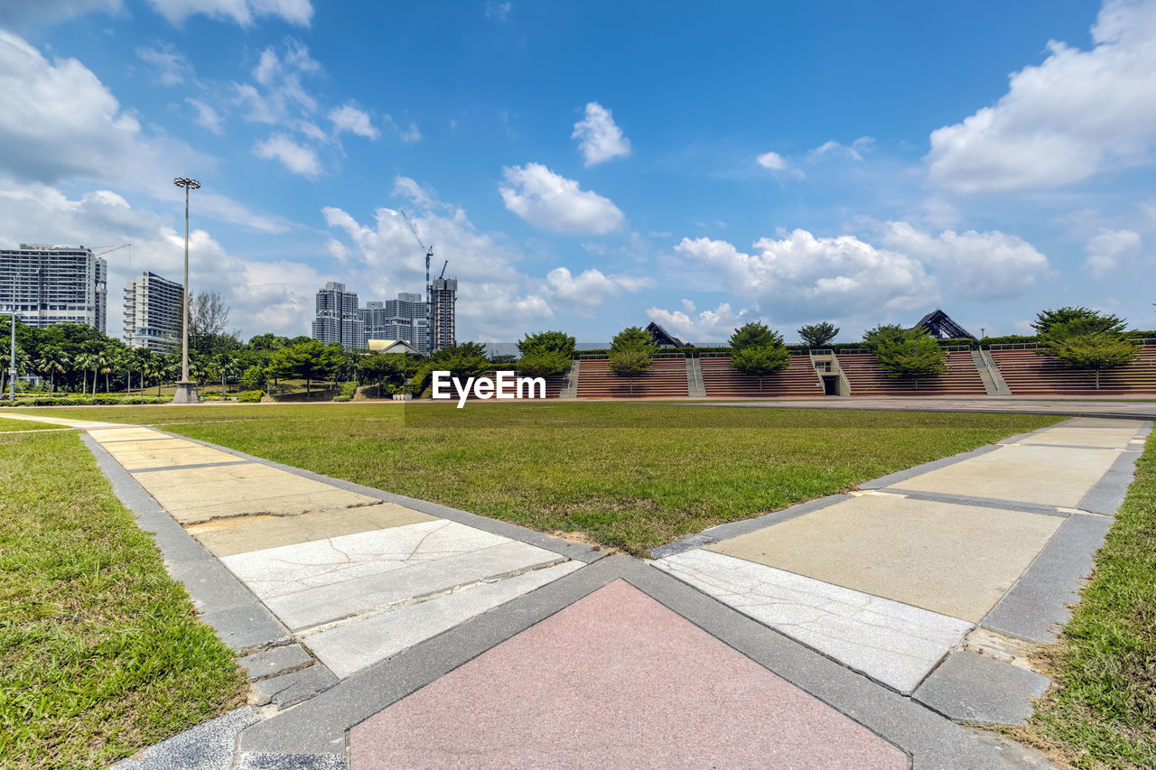 Park by buildings against sky in city