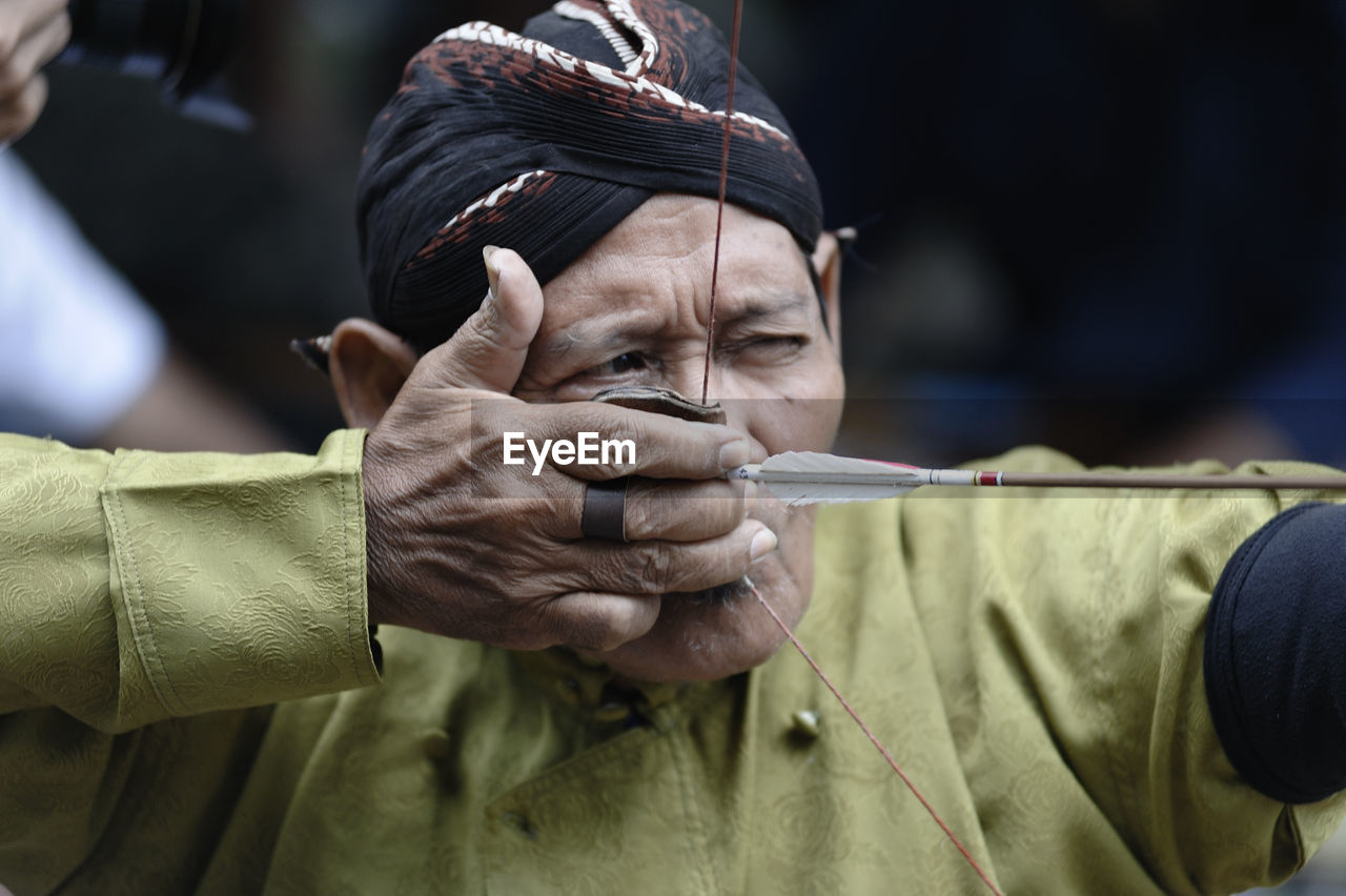 Man aiming while holding bow and arrow