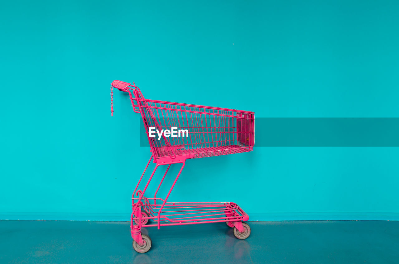 Shopping cart against blue wall