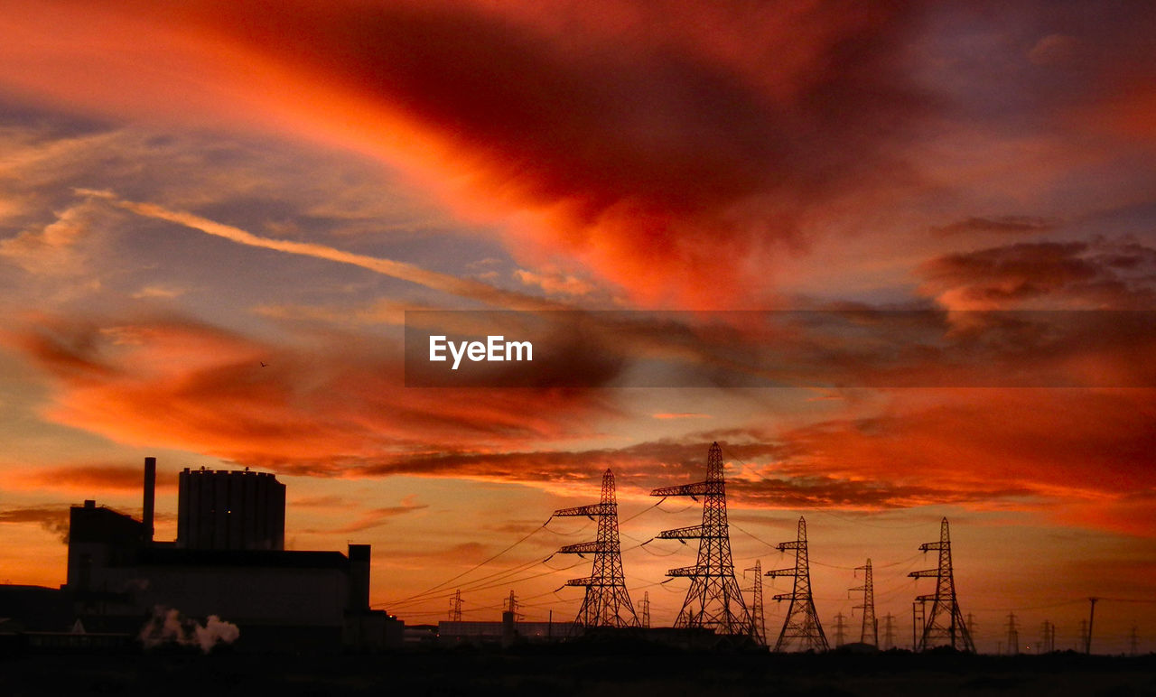 LOW ANGLE VIEW OF SILHOUETTE FACTORY AGAINST ORANGE SKY