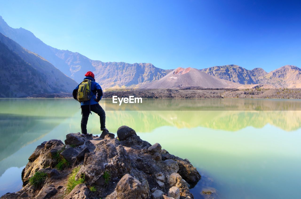 Man looking at lake against mountain range