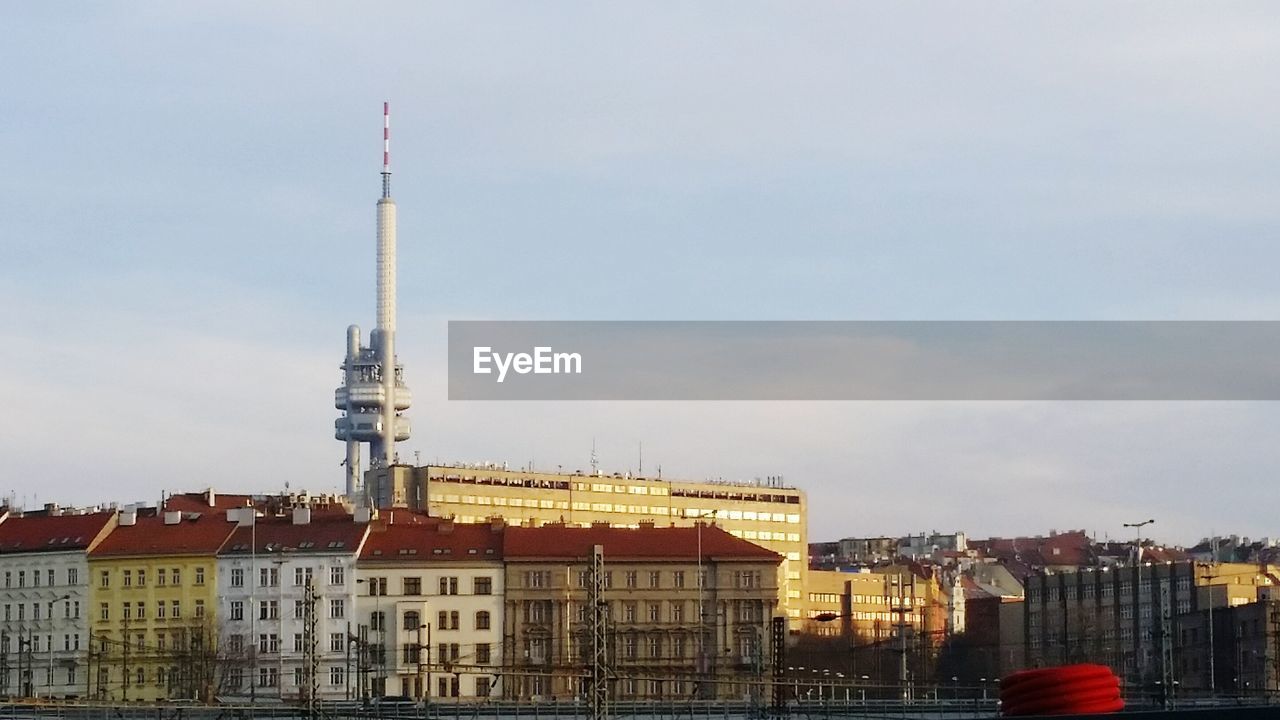 Zizkov television tower amidst buildings against cloudy sky in city