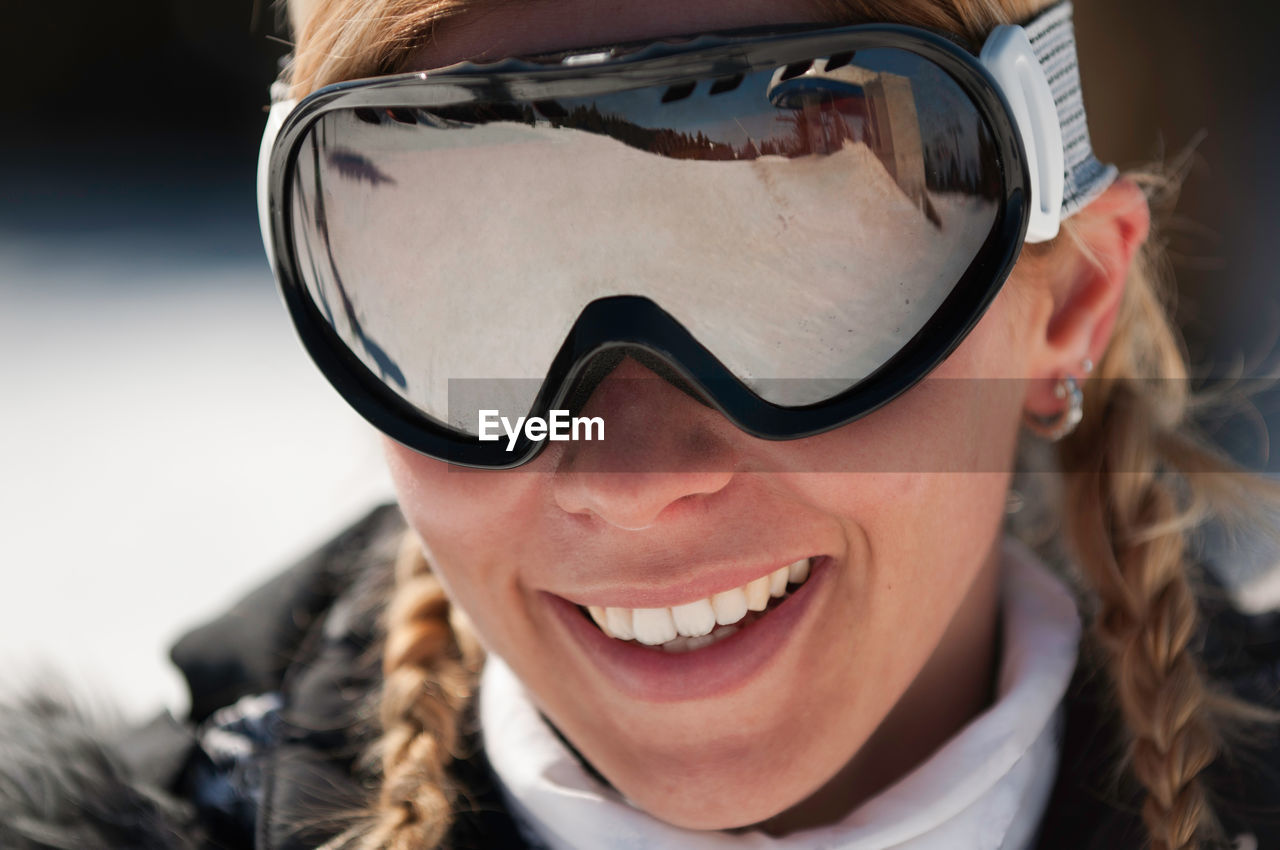 Close-up portrait of smiling mid adult woman wearing ski goggles