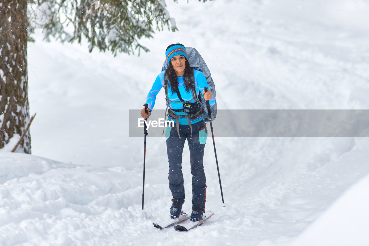 A beautiful young woman practicing hiking skiing alone