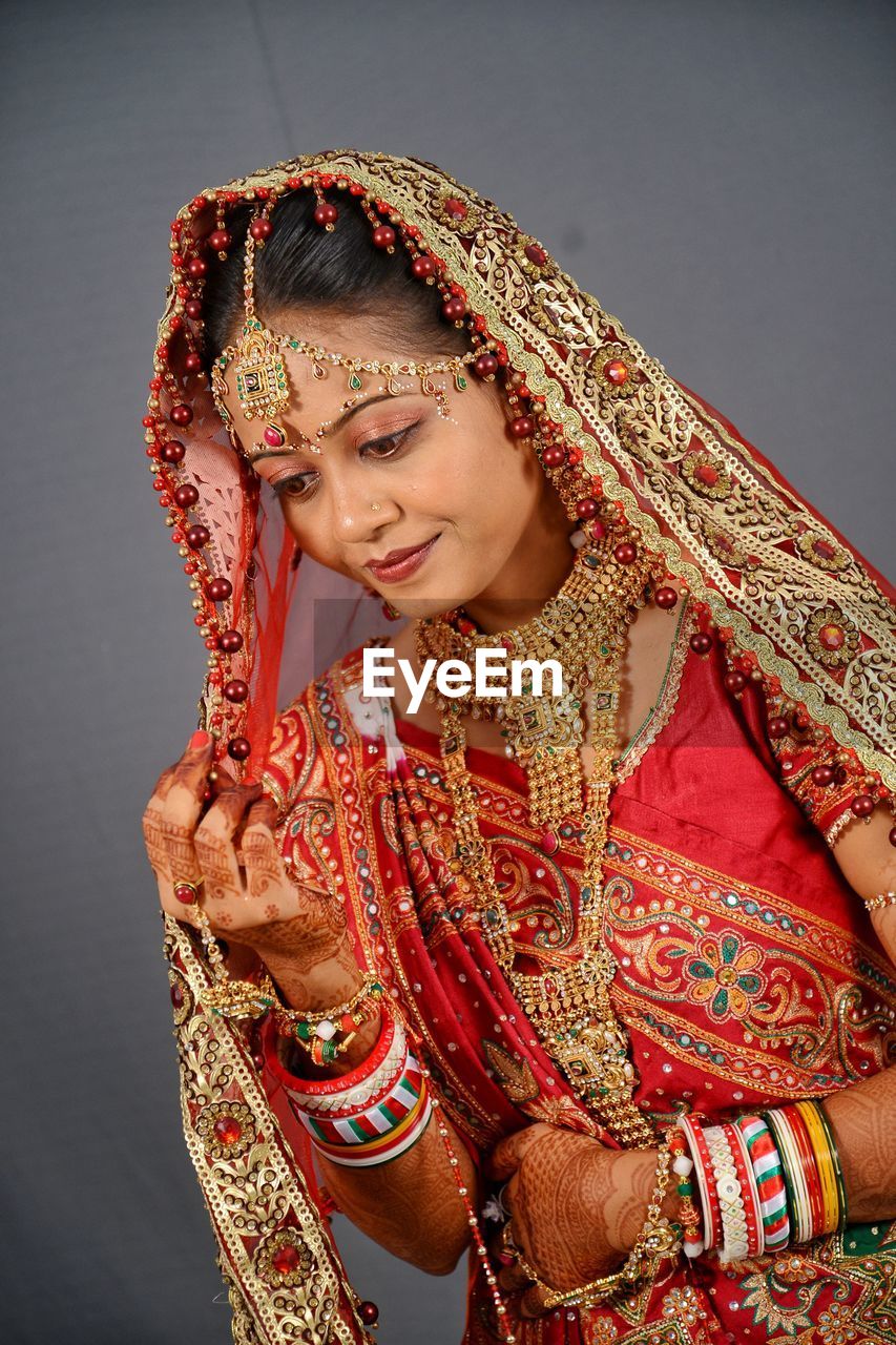 Beautiful young bride standing against wall