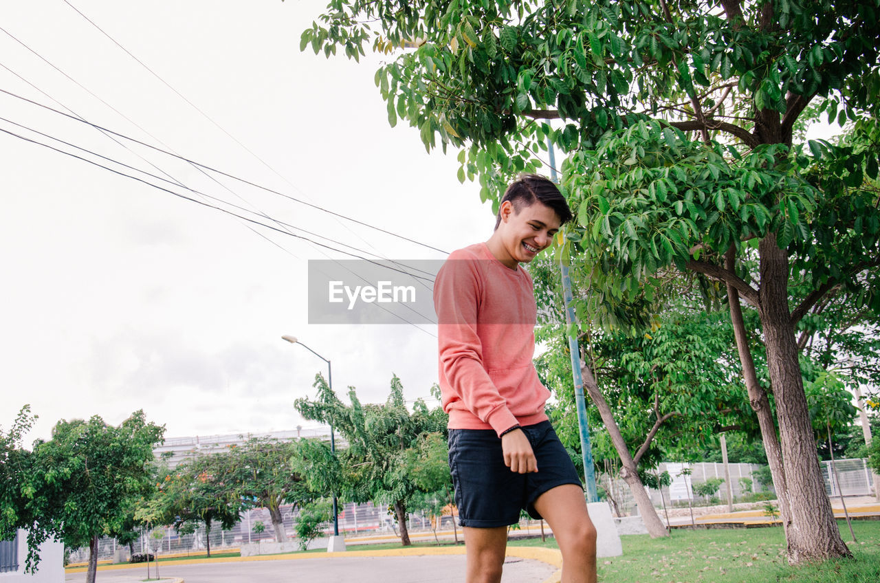 Man walking in park against trees