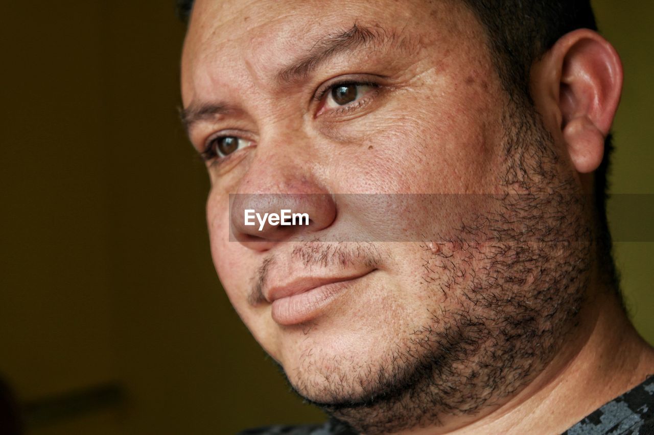 Close-up mid adult man sitting at home