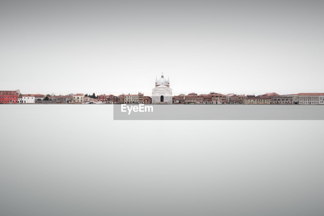 Historic building by river against sky