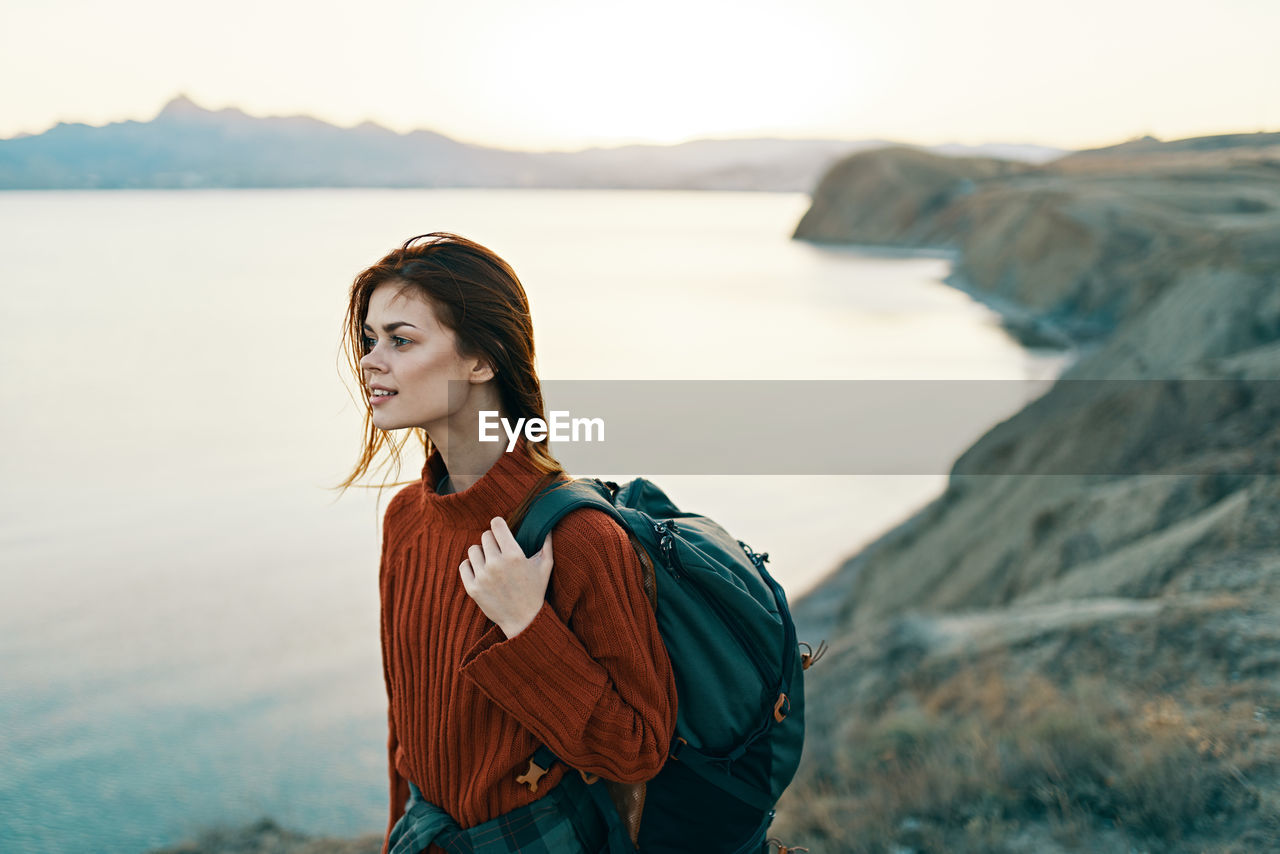 PORTRAIT OF BEAUTIFUL WOMAN STANDING ON BEACH