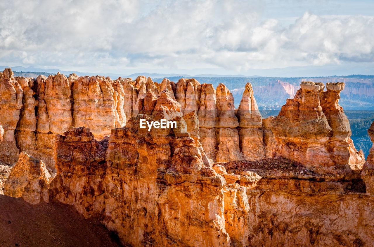 Scenic view of rocky mountains against cloudy sky