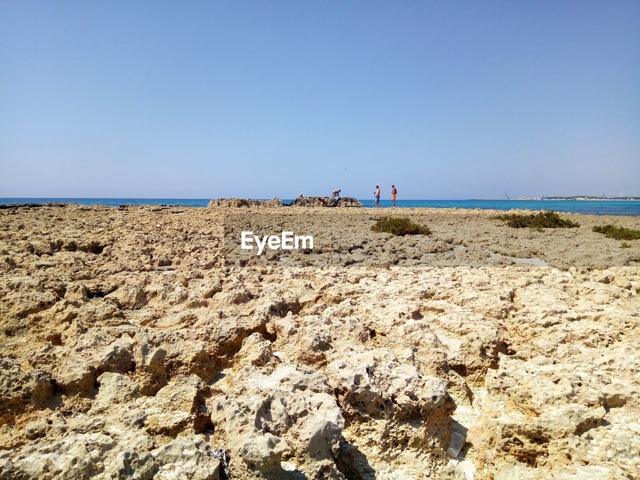 SCENIC VIEW OF ROCKS ON BEACH AGAINST CLEAR SKY