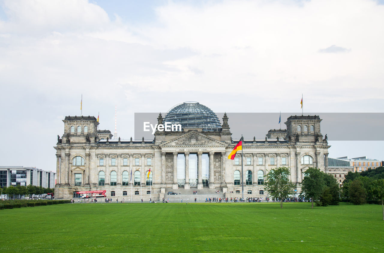 Facade of reichstag building against cloudy sky