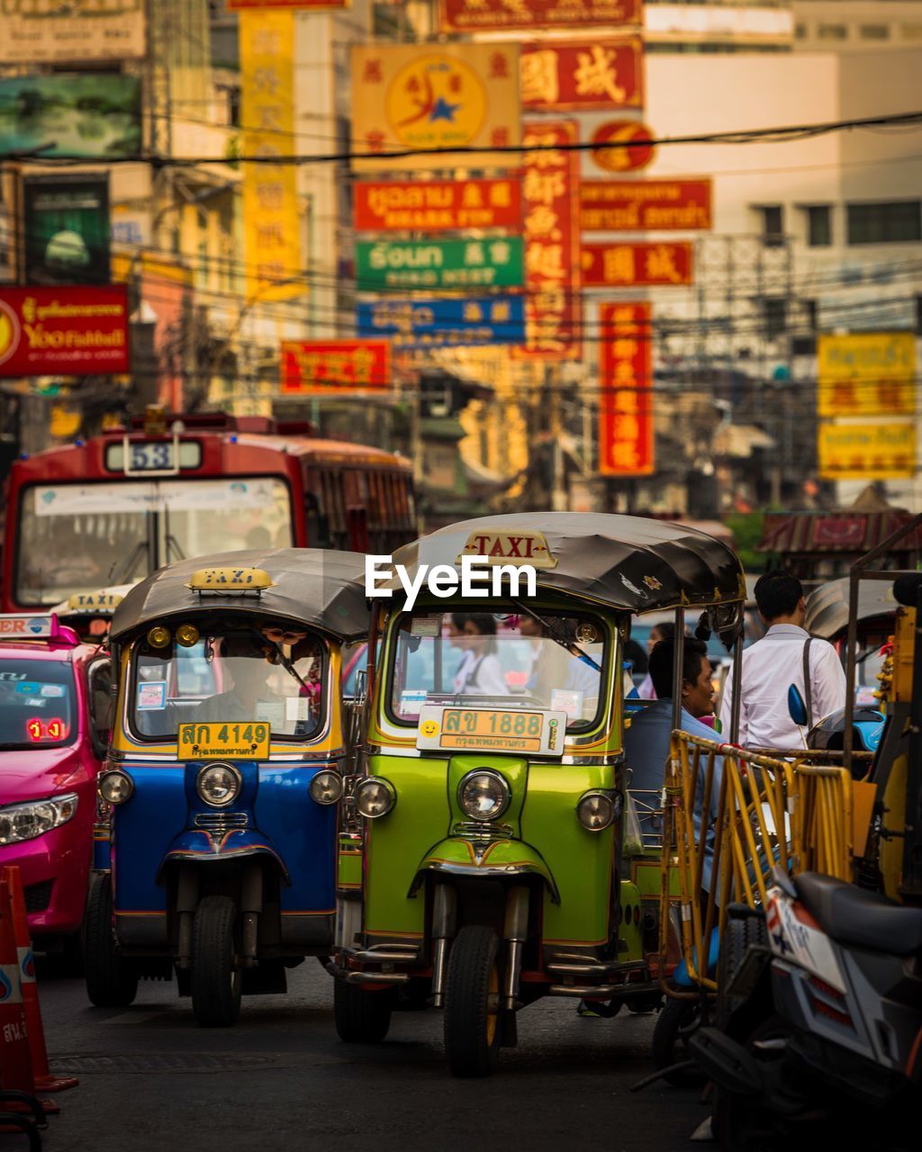 CARS ON STREET AGAINST MULTI COLORED CITY