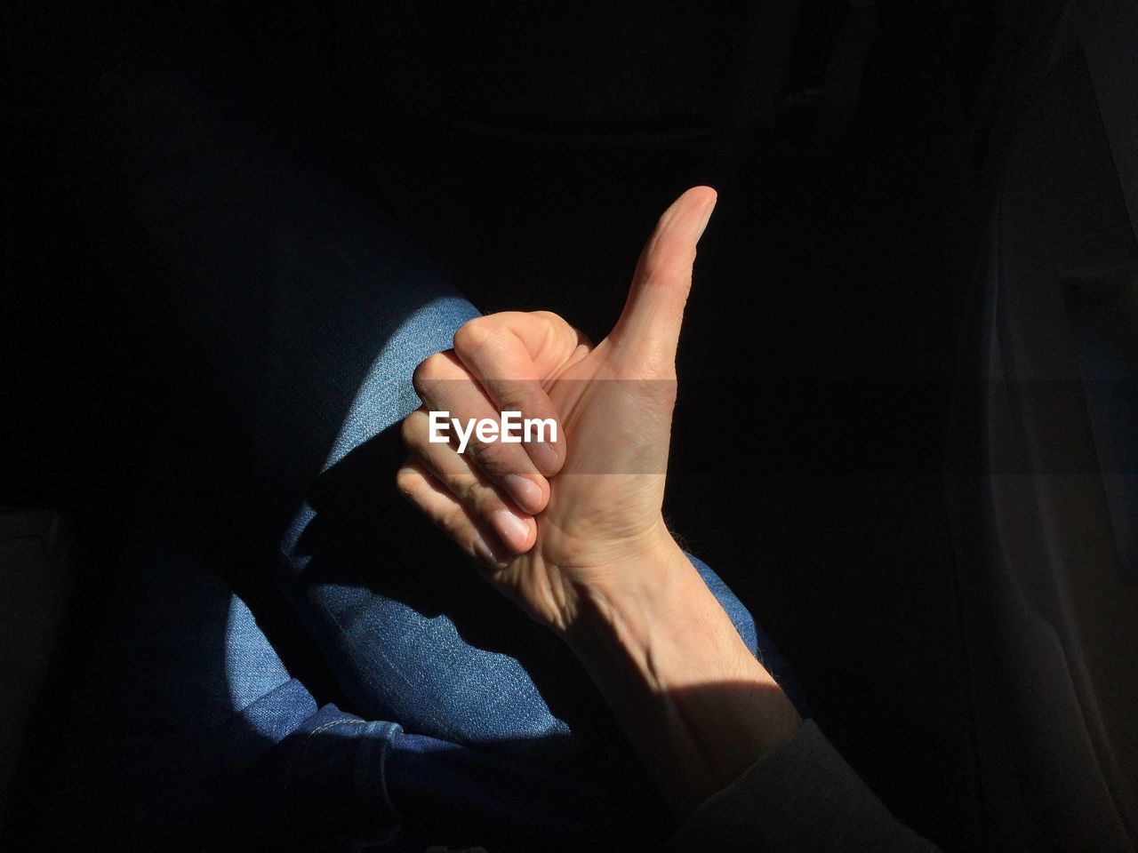 Cropped image of hand showing thumbs up in airplane