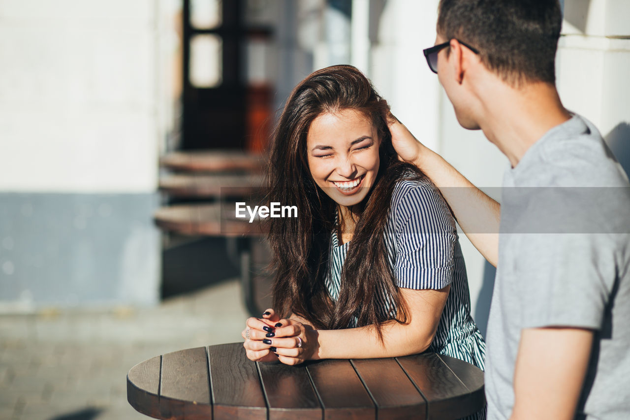 Smiling young couple sitting at cafe