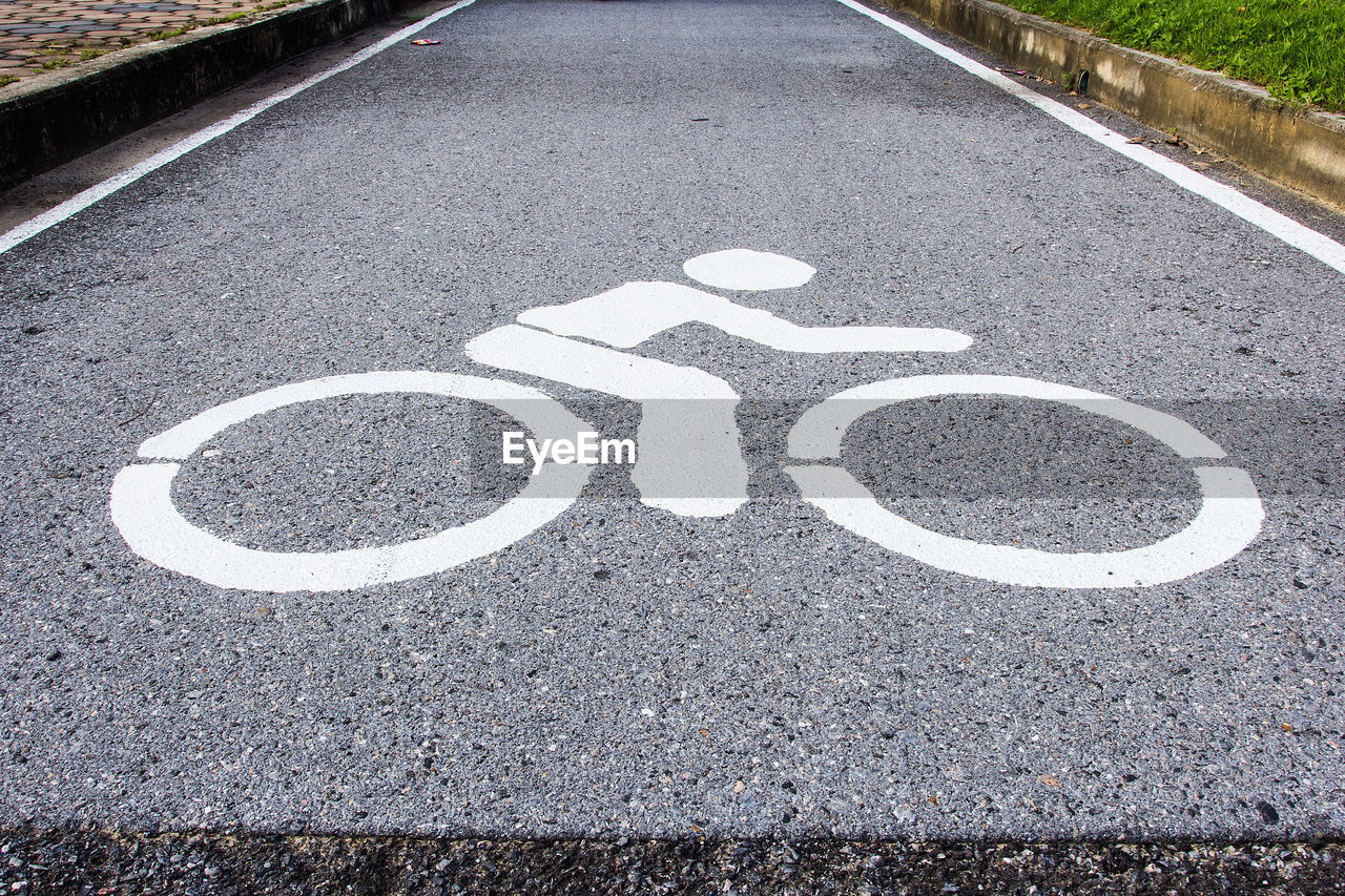 lane, road, sign, transportation, road surface, asphalt, communication, symbol, road marking, no people, bicycle, day, city, marking, tarmac, bicycle lane, sidewalk, high angle view, street, infrastructure, guidance, road sign, pedestrian crossing, representation, human representation, white, outdoors, disabled access, zebra crossing, the way forward, line