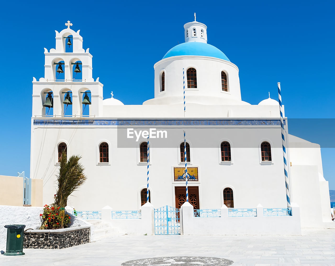 Low angle view of church in oia village against clear blue sky at santorini
